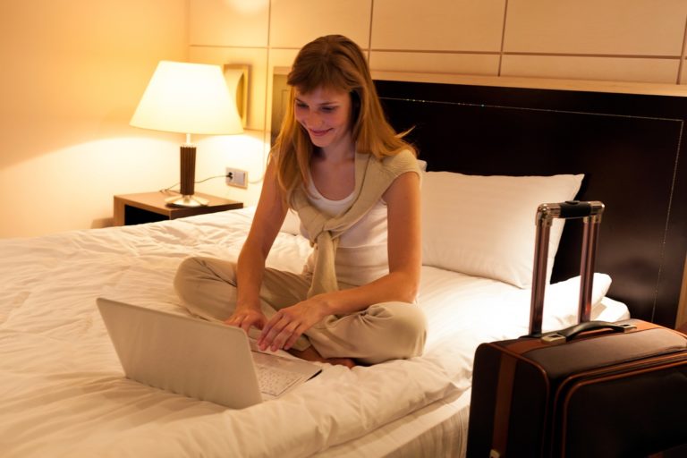 woman using laptop on her bed
