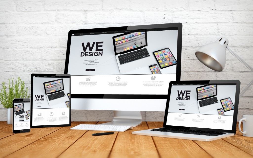 Gadget screens with the word WE DESIGN as a web design concept